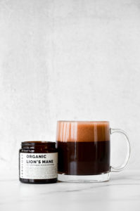 Hot cocoa or hot chocolate with lion's mane mushroom powder on a marble background.